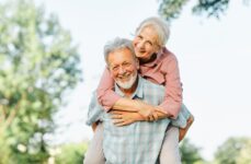 An older couple smiling during a piggyback ride while touring a local park in Rio Rancho.